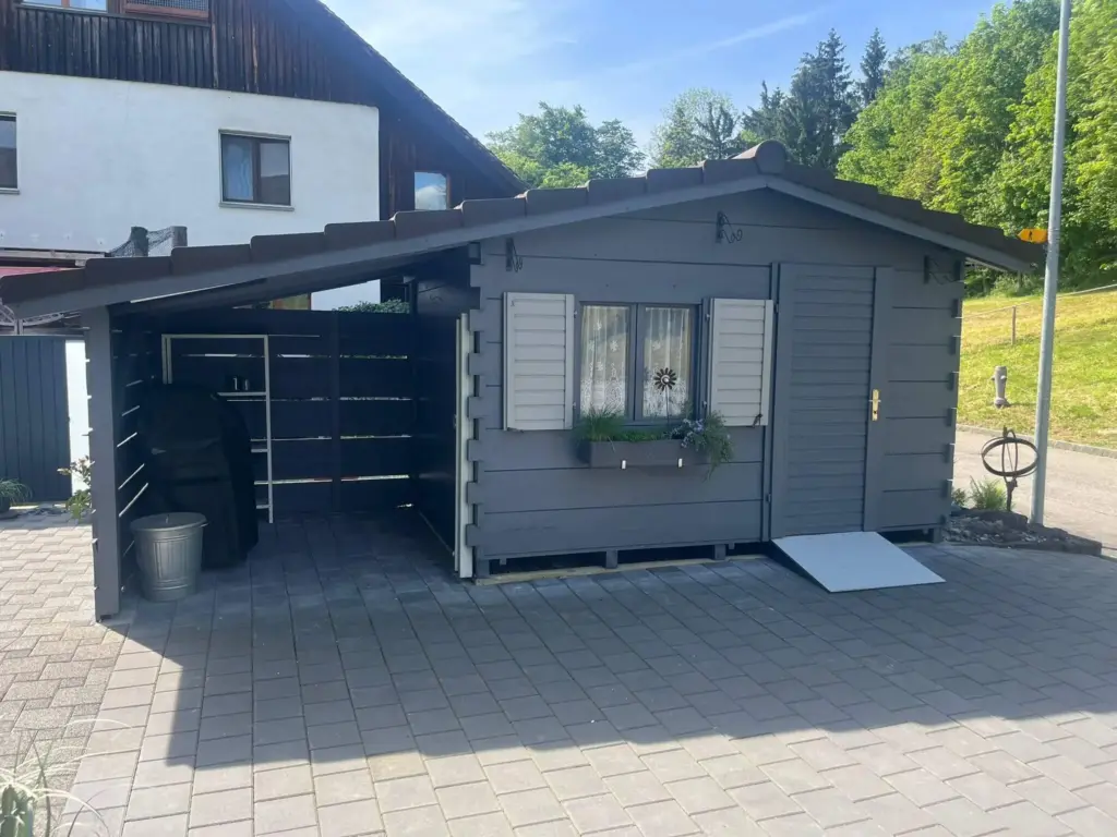 Dasselbe Gartenhaus nach dem Neuanstrich in Anthrazit mit hellen Fensterläden
