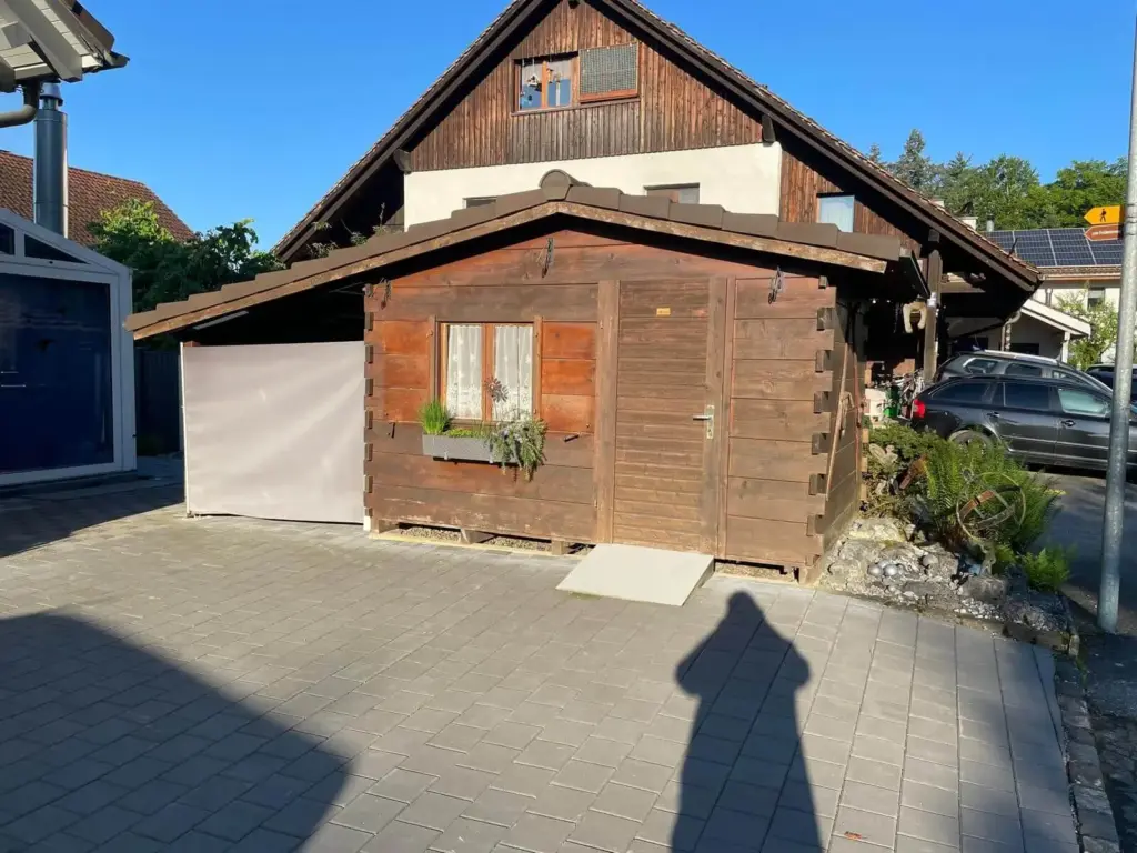 Gartenhaus aus verwittertem braunem Holz vor dem Neuanstrich