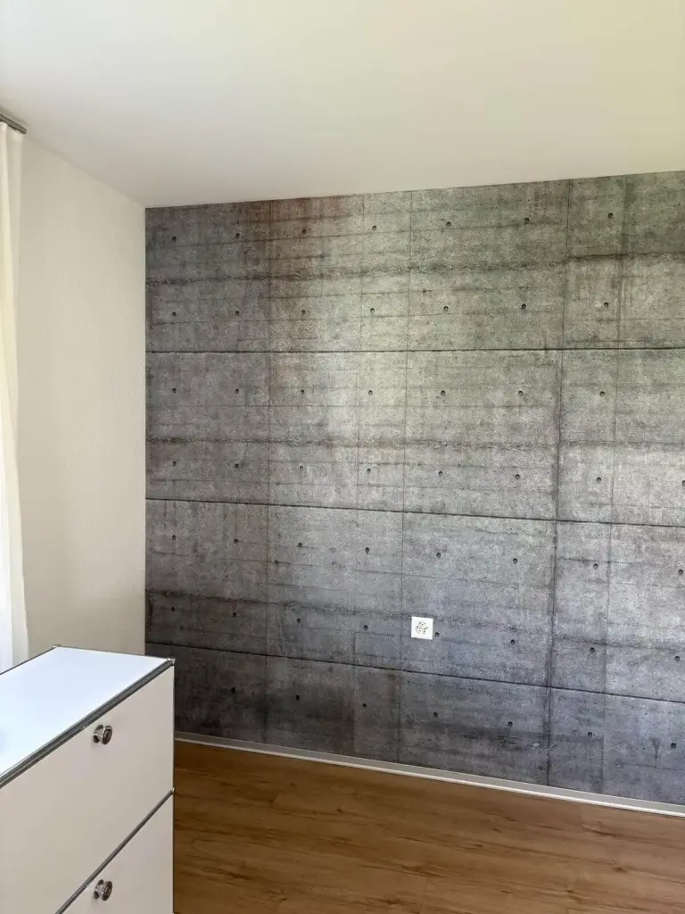 Dieselbe Wand nach dem Tapezieren mit einer Tapete in Betonoptik