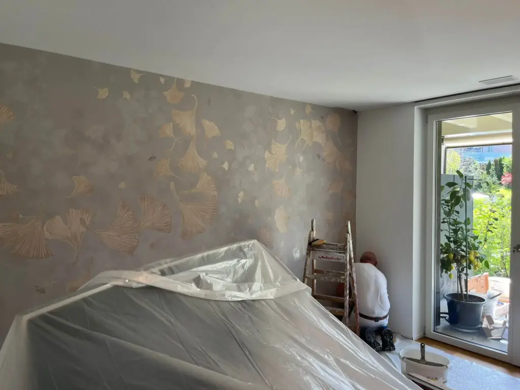Wohnraumwand mit goldener Ginkgo-Spachteltechnik