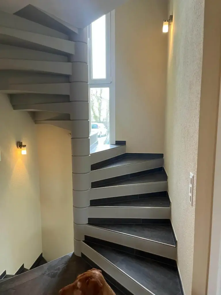 Frisch gestrichenes Treppenhaus in warmem Beige mit dunklen Trittstufen